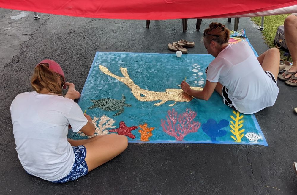 A mom and daughter painting on the street
